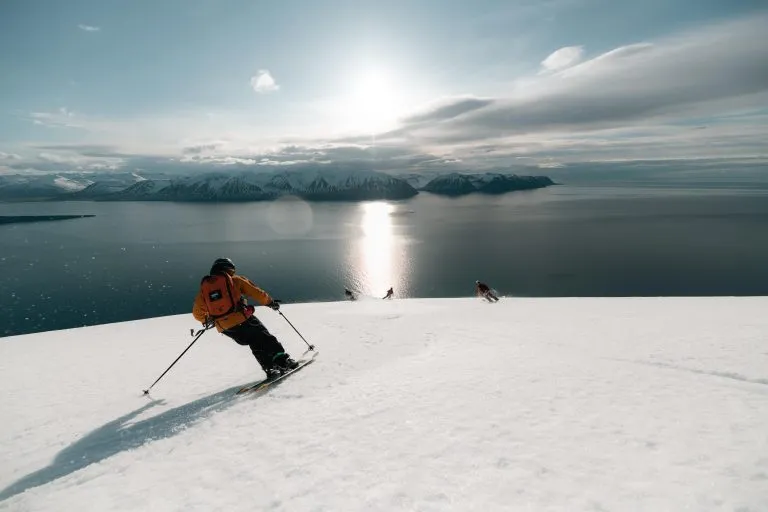 skiers descending snowy mountain